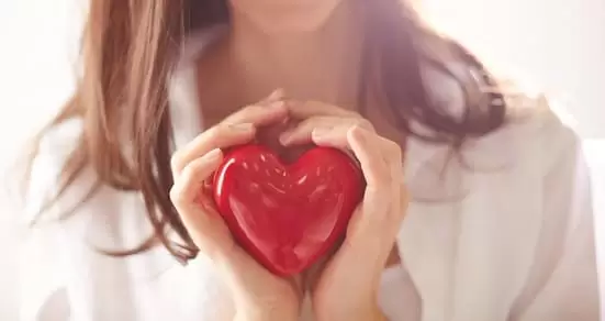 Coração na mão de uma mulher mostrando que ela se ama e tem Autoestima